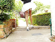 Tan Stockings With Pleated Skirt On A Windy Day