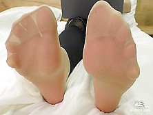 Mistress Feet In Soft Nylon Socks Is Resting On The Bed
