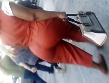 Older Lady With A Phatty In Orange Outfit.