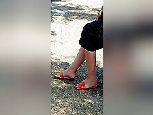 Candid Legs And Feet In Orange Sandals Of A Brunette Woman At The Bus