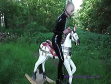 Blonde In Latex Riding Horse