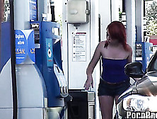 Striking Redhead In A Blue Tube Top And Short Shorts Is Recorded As She Pumps Her Gas.