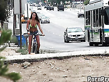 Hottie In A Green Bikini Top And Jean Shorts Is Filmed As She Rides Her Bike In Public.