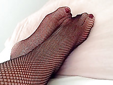Feet And Legs In Black Fishnet Tights