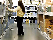 Dame In A Yellow Top And Black Pants Is Followed Around And Recorded In A Store.